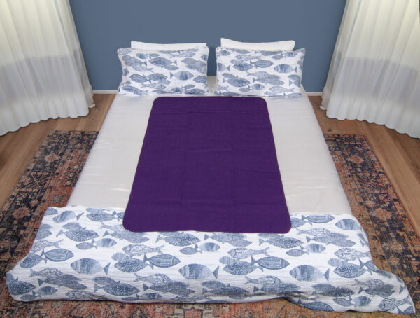 Dark Purple Waterproof Sex blanket on a white bed with fishes cover