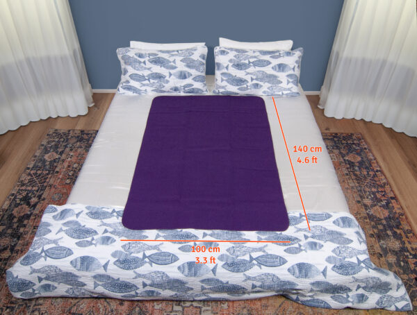 Dark Purple Waterproof Sex blanket on a white bed with fishes cover. The measurements are 140x100cm of the sex blanket