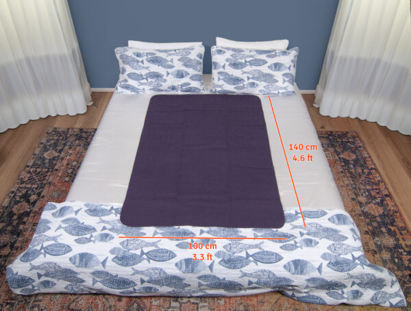 Heather Grey Waterproof Sex blanket on a white bed with fishes cover. The measurements are 140x100cm of the sex blanket