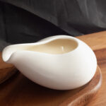 Beautiful white jar massage candle with a black background