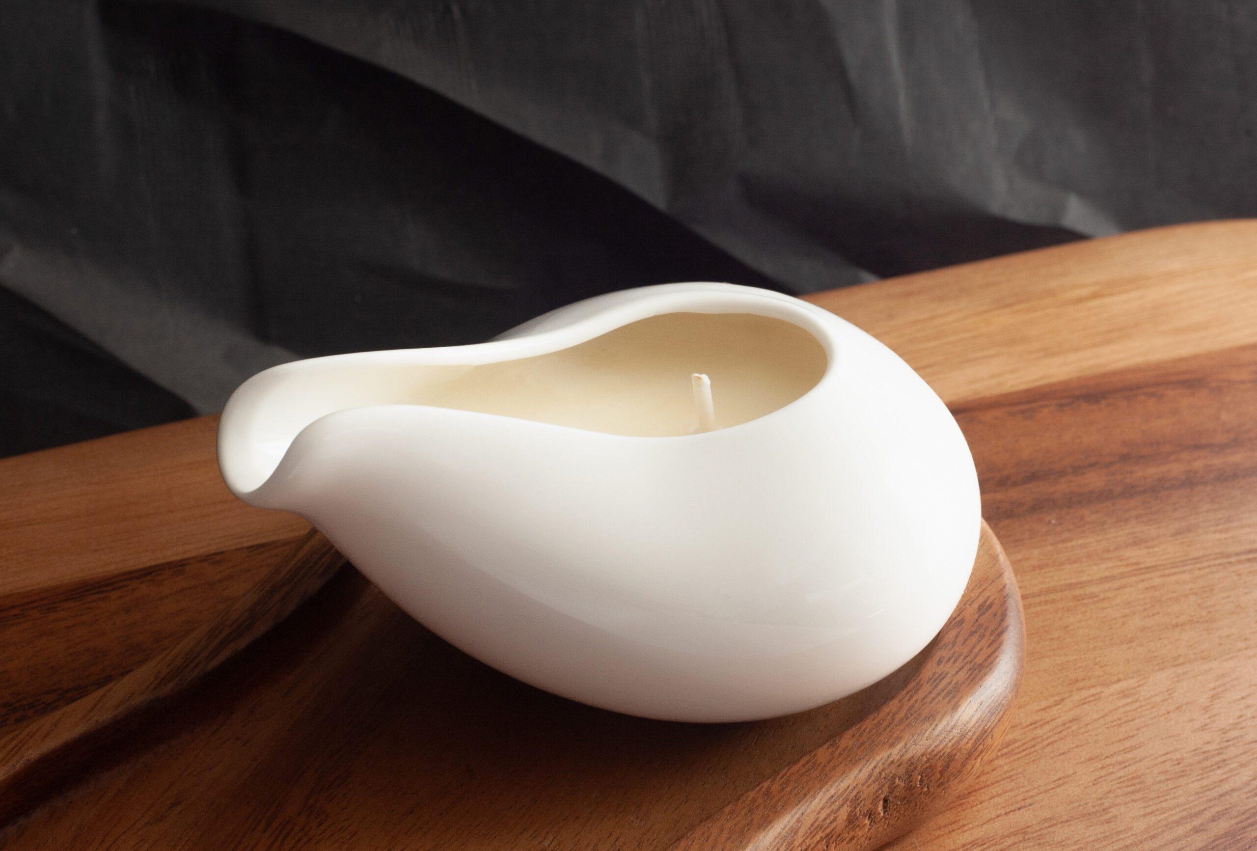 Beautiful white jar massage candle with a black background