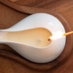 Massage candle in a white jar about to be lit