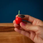 Cute red cherry candle held by a woman in her hands