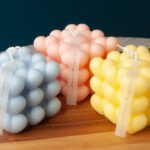 Blue, pink and Yellow heart bubble candle on a wooden platter