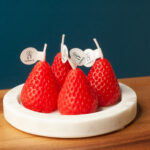 4 Strawberry Novelty candles on a marble base