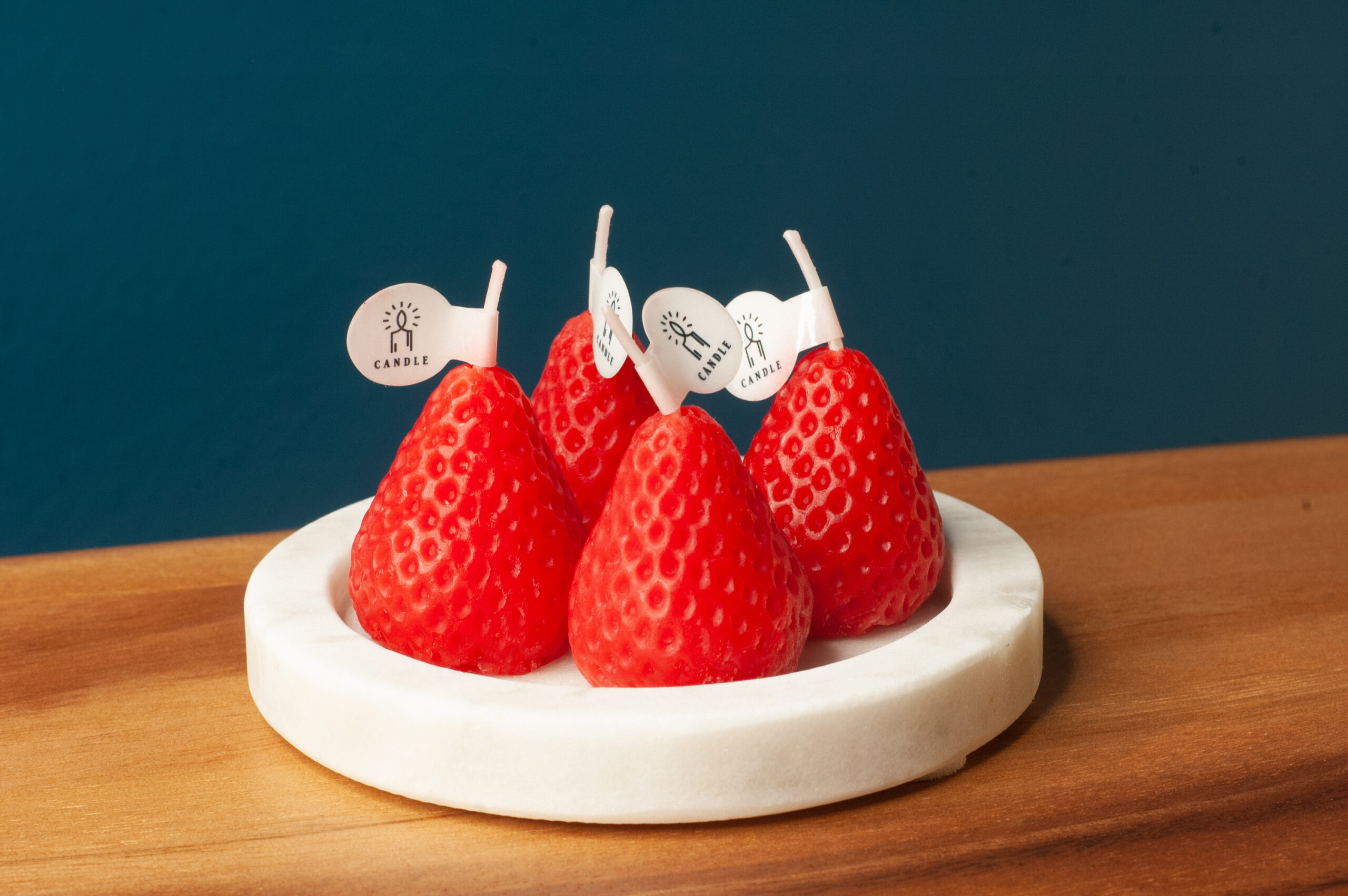 4 Strawberry Novelty candles on a marble base
