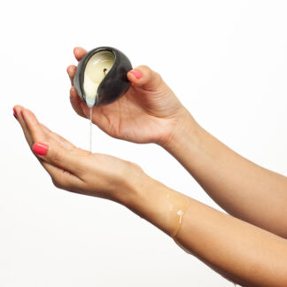 Massage oil melted from a massage candle being dripped on hands