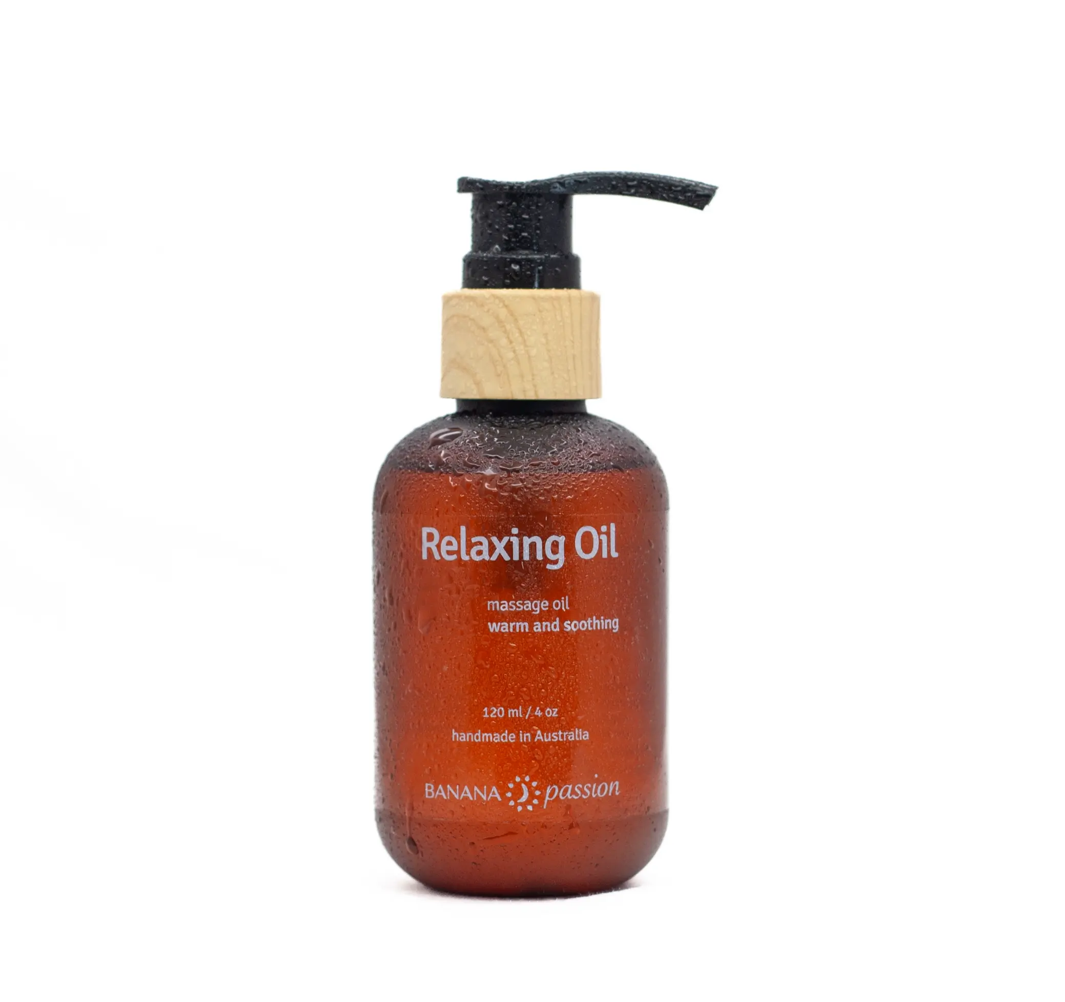 An amber plastic bottle with a bamboo looking pump contains 120 ml Relaxing Body Massage Oil. Its handmade in Australia by Banana Passion. Bottle has some water droplets on it to make it look sensational
