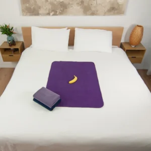 Dark Purple Waterproof Sex blanket on the bed with two other waterproof blankets next to it. These waterproof splash sex blankets are grey, and navy blue in colour. Splash blankets, sex blankets, waterproof blankets, these are some of the names used for our absorbent sex sheets.