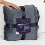 Grey Waterproof Blanket packaging which is minimalistic. The sex blanket packaging is black ribbon and a card.