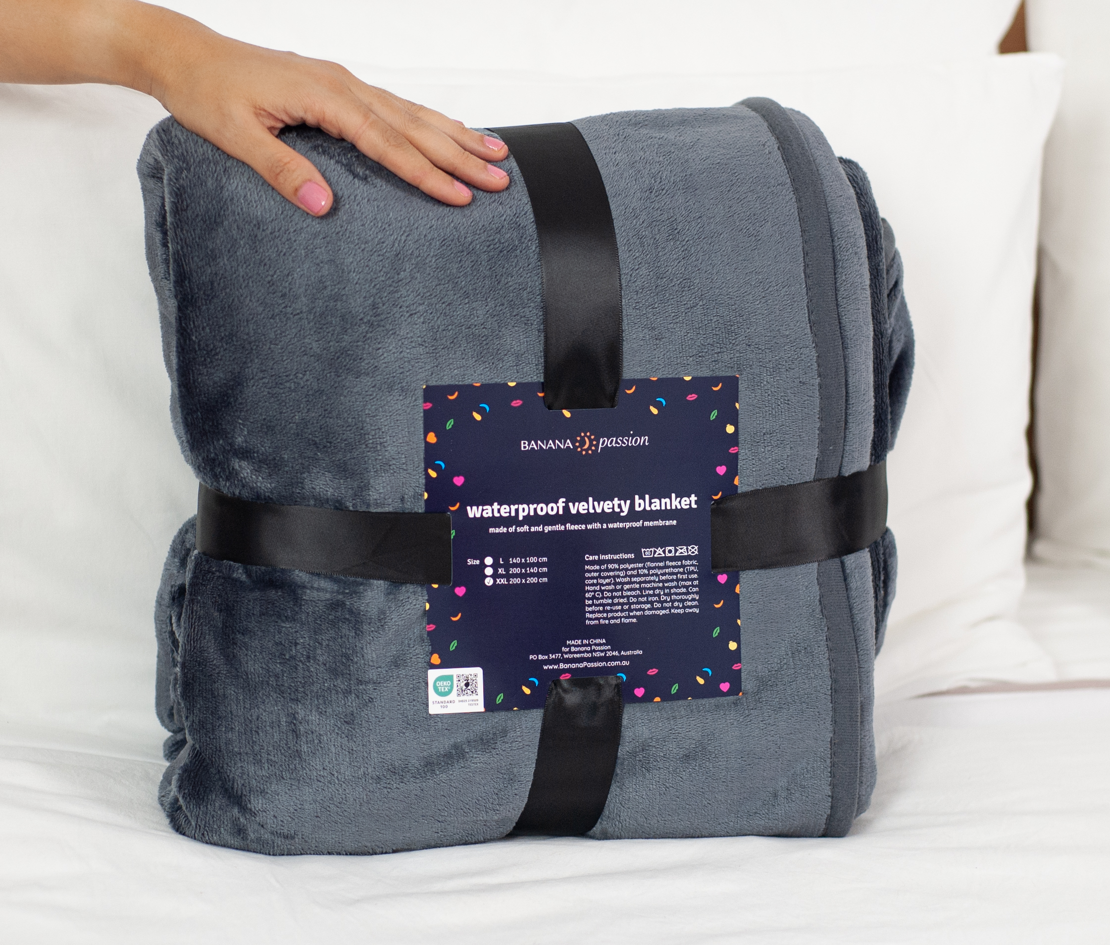 Grey Waterproof Blanket packaging which is minimalistic. The sex blanket packaging is black ribbon and a card.