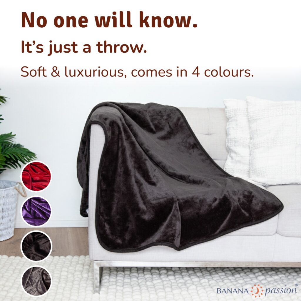 Black velvety waterproof throw on a sofa, soft leakproof couch blanket that protects from spills, pets and messy intimacy while looking like a normal cosy throw.