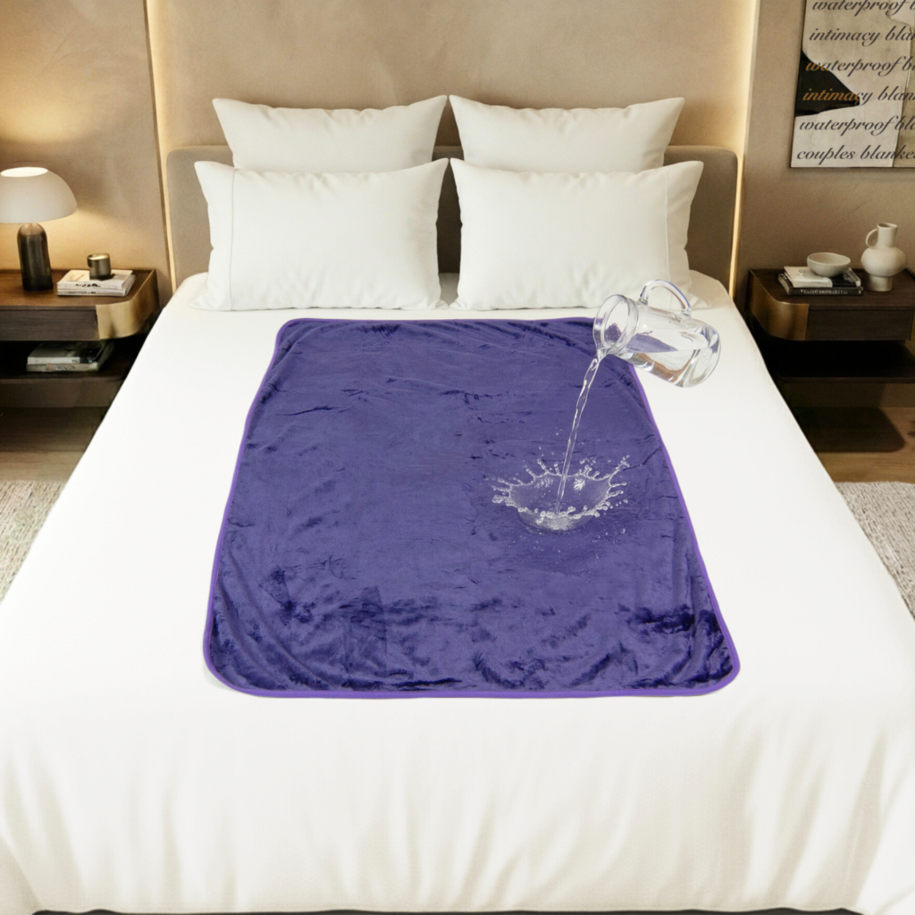 Purple Banana Passion waterproof blanket in large size spread over a bed, showing the cosy polar fleece surface and discreet waterproof intimacy blanket design that keeps sheets dry during wet, splashy moments.