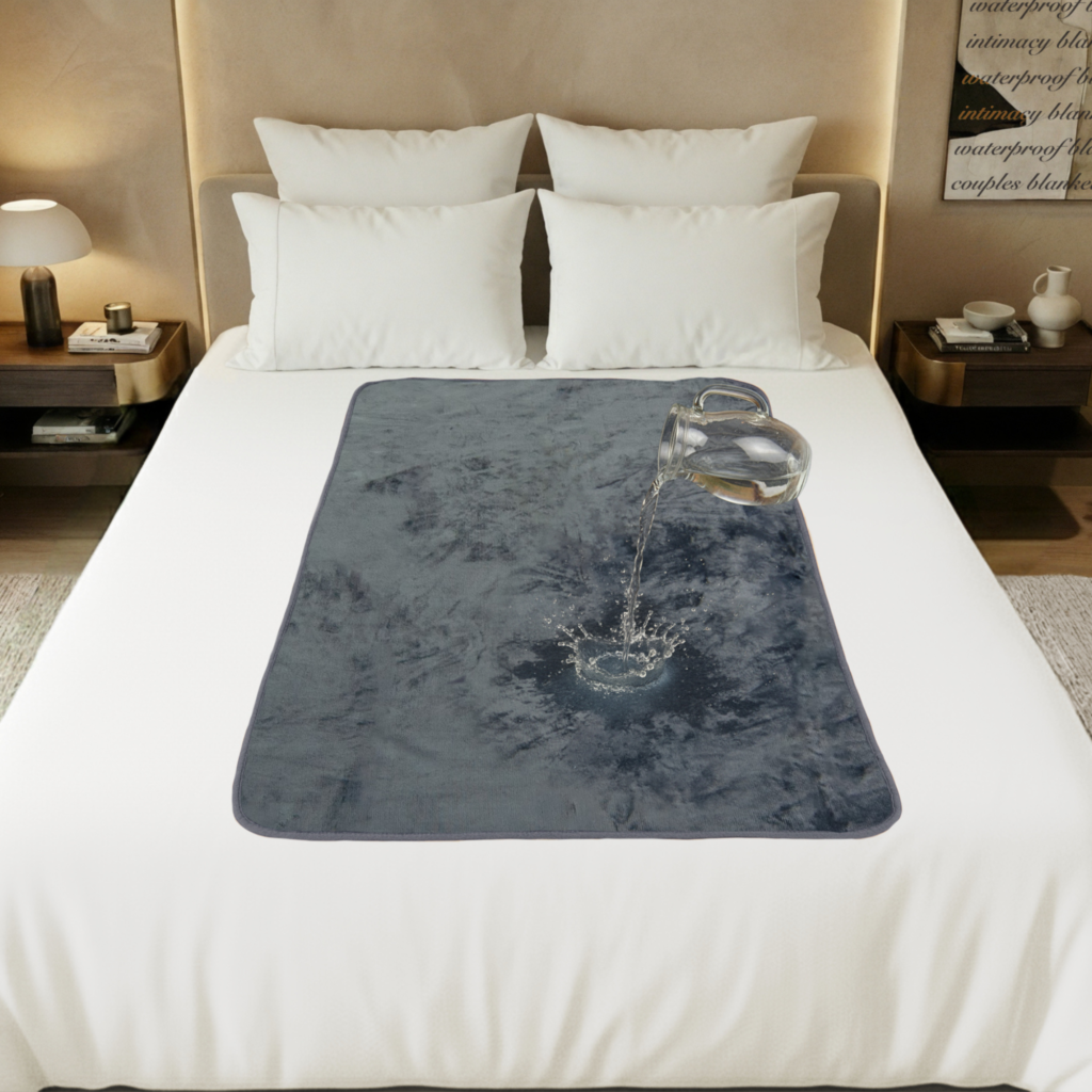 Grey velvety waterproof blanket in large size spread neatly over a bed, showing the soft flannel fleece intimacy blanket surface that keeps sheets dry during wet, splashy moments. This Banana Passion sex blanket is the best blanket in town.