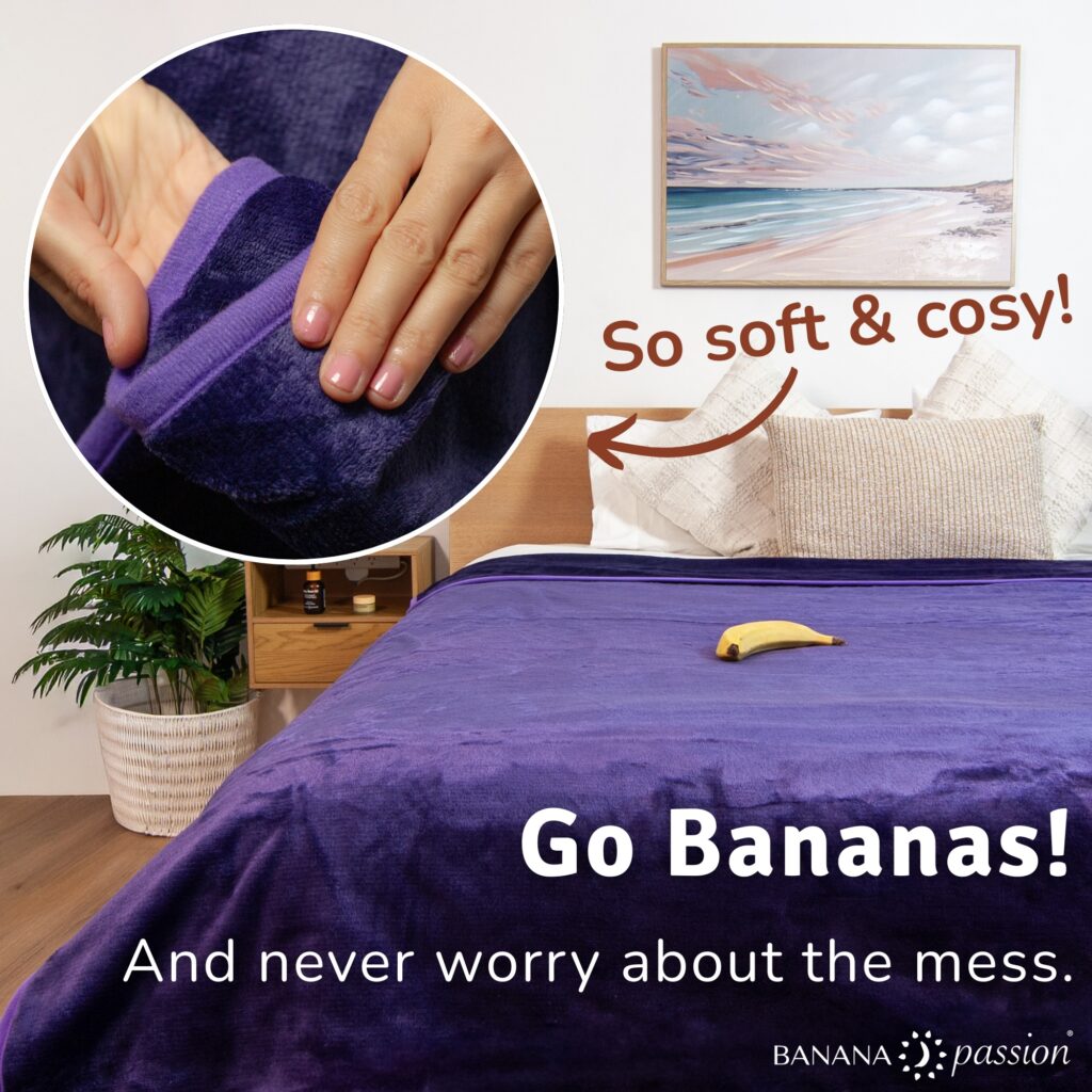 Banana Passion waterproof blanket in large size spread over a bed, showing the cosy fleece surface and discreet waterproof intimacy blanket design that keeps sheets dry during wet, splashy moments.