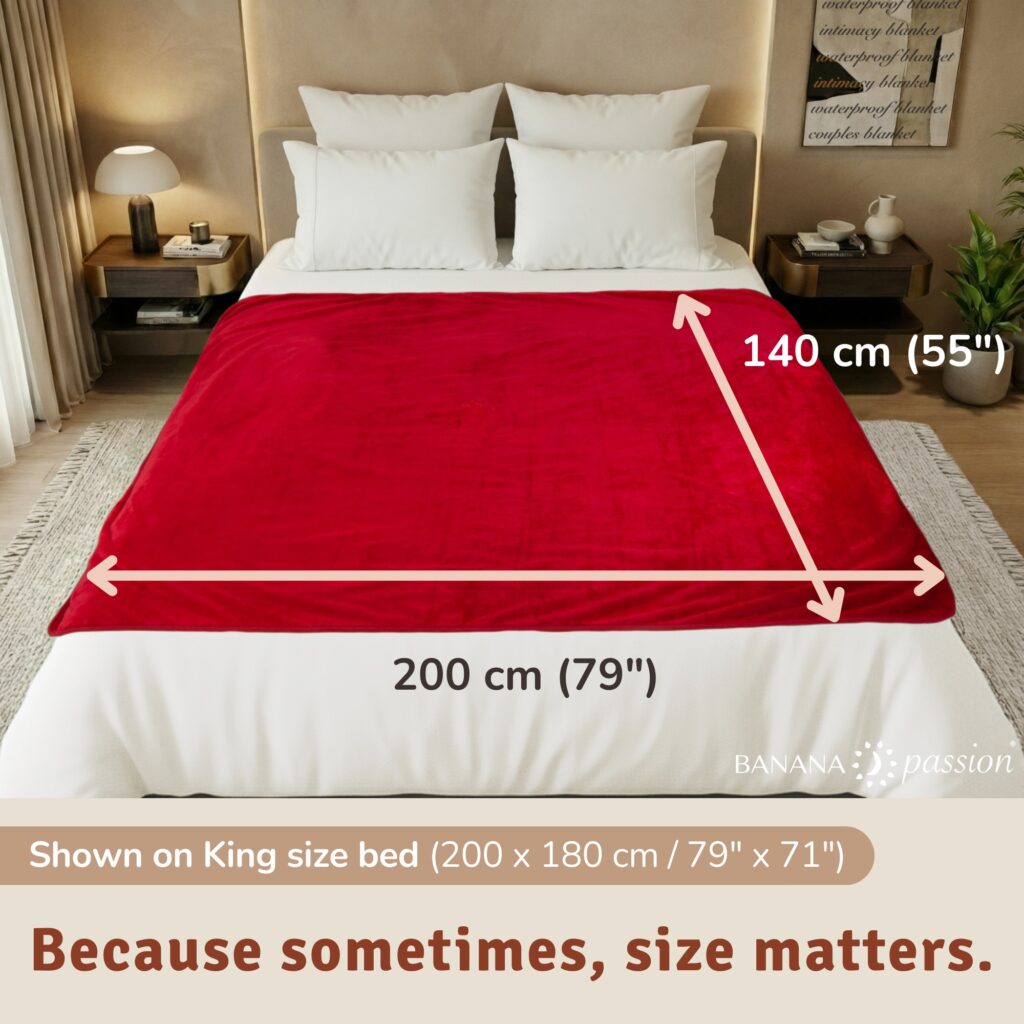 Passion red velvety waterproof blanket on a bed, extra-large intimacy blanket protecting the sheets.