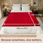 Passion red velvety waterproof blanket on a bed, extra-large intimacy blanket protecting the sheets.