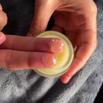 Opening the jar and taking a small dab of sensual balm