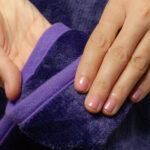 Purple Waterproof Blanket in the hands of a woman showcasing it is soft. This is exactly like squirt blanket or liberator throw. Best squirt blanket.
