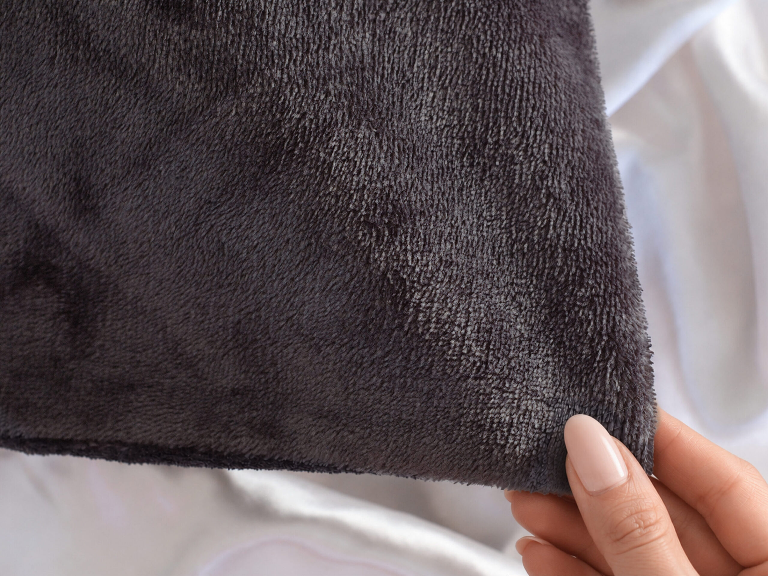 Texture of the splash proof protector - grey in colour. This is waterproof, absorbent, stainproof and oeko tested. Charcoal grey flannel fleece fabric close-up, waterproof pillow protector