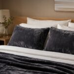 Dark grey waterproof pillow protectors on a bed, soft flannel fleece fabric